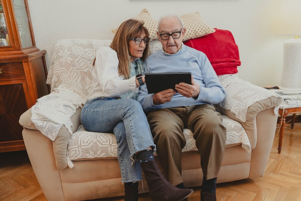 Older couple using tablet on living room couch