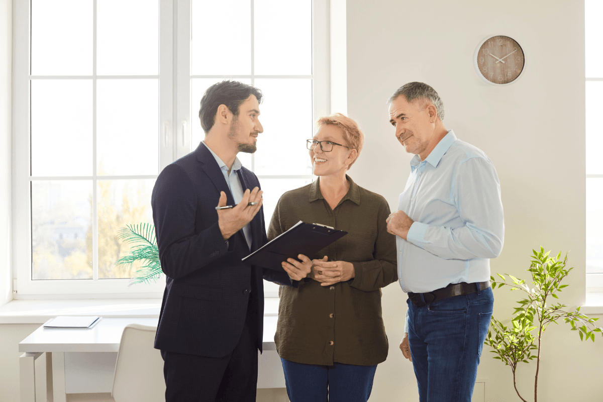 Elderly couple explores a property or apartment with a real estate agent or realtor, considering purchase or rental options.