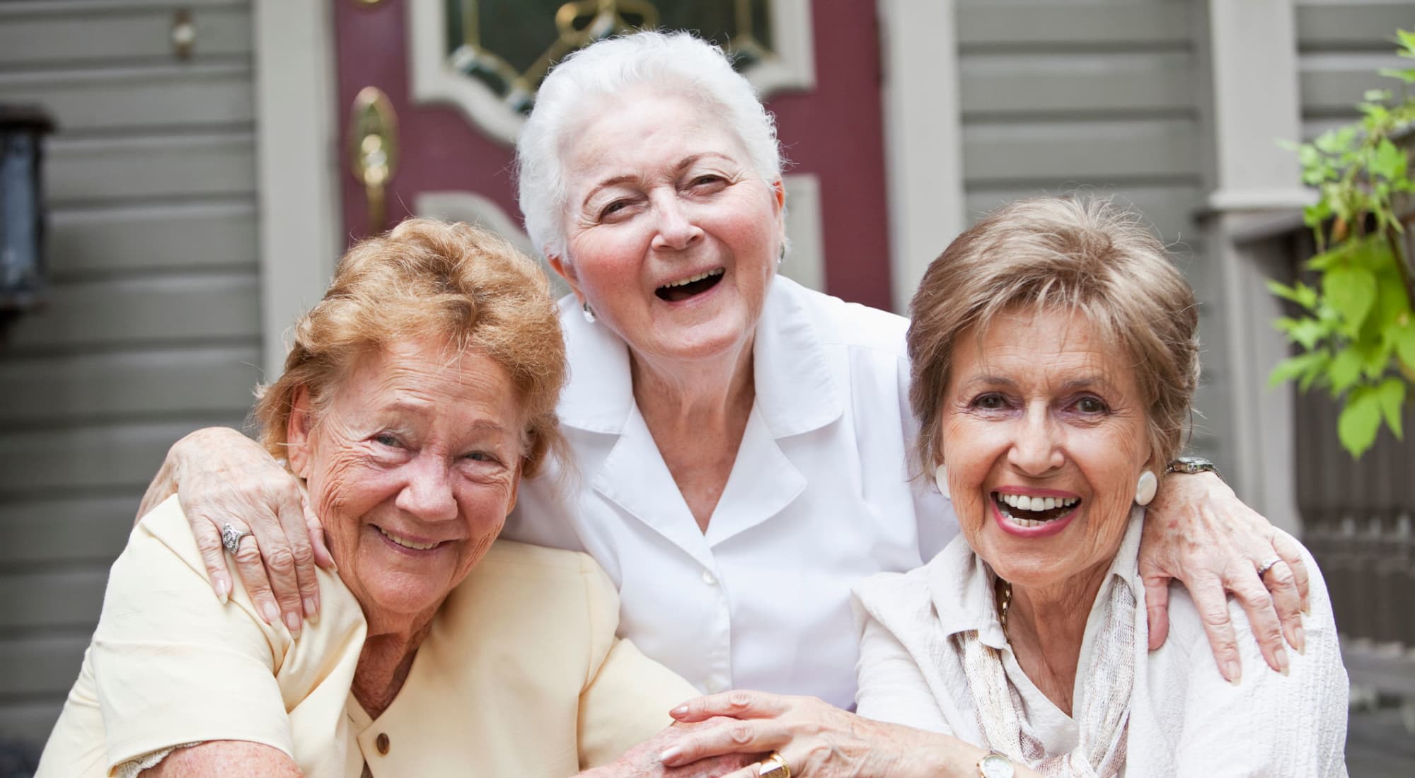 Three senior women smiling together outdoors