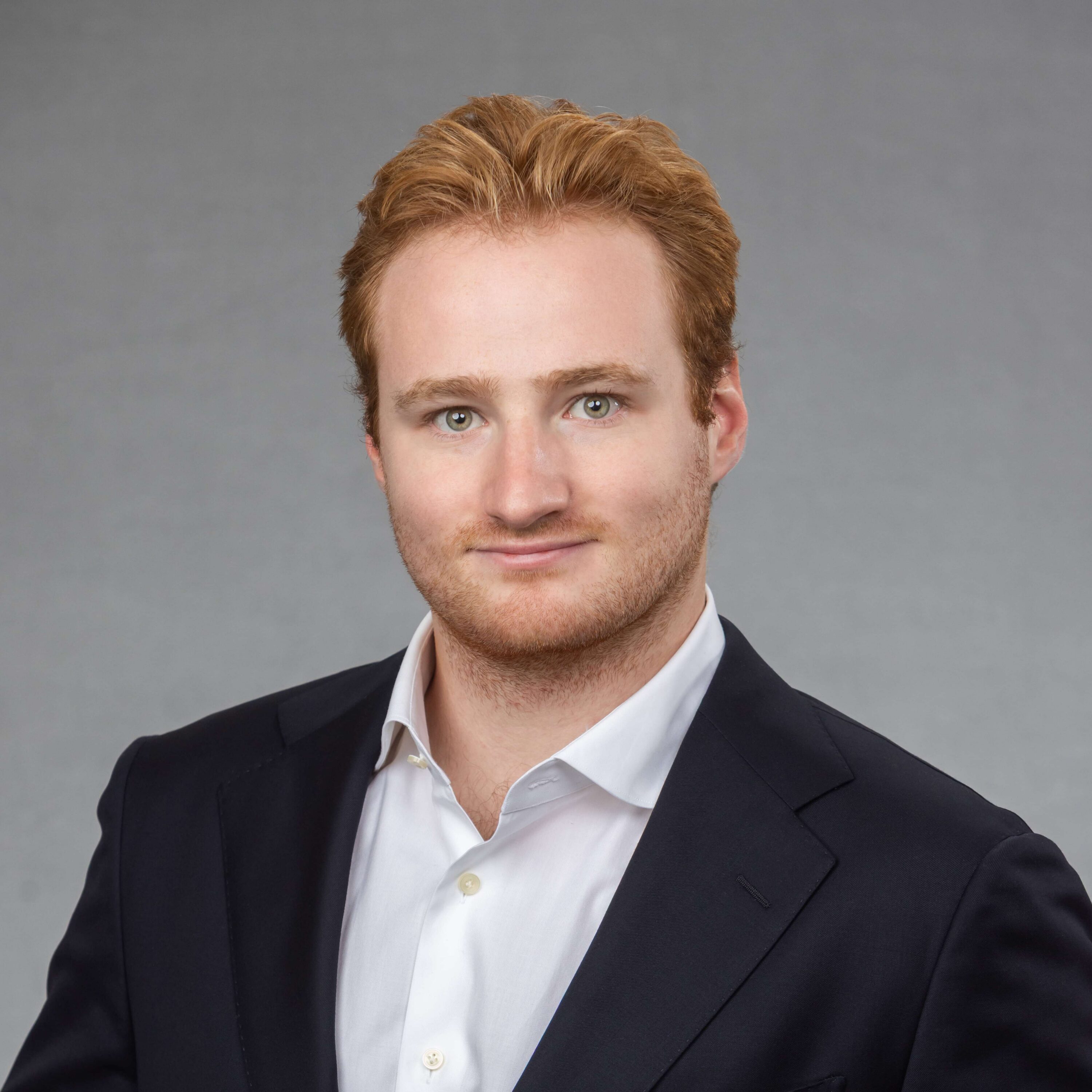 Professional headshot of man in suit and white shirt