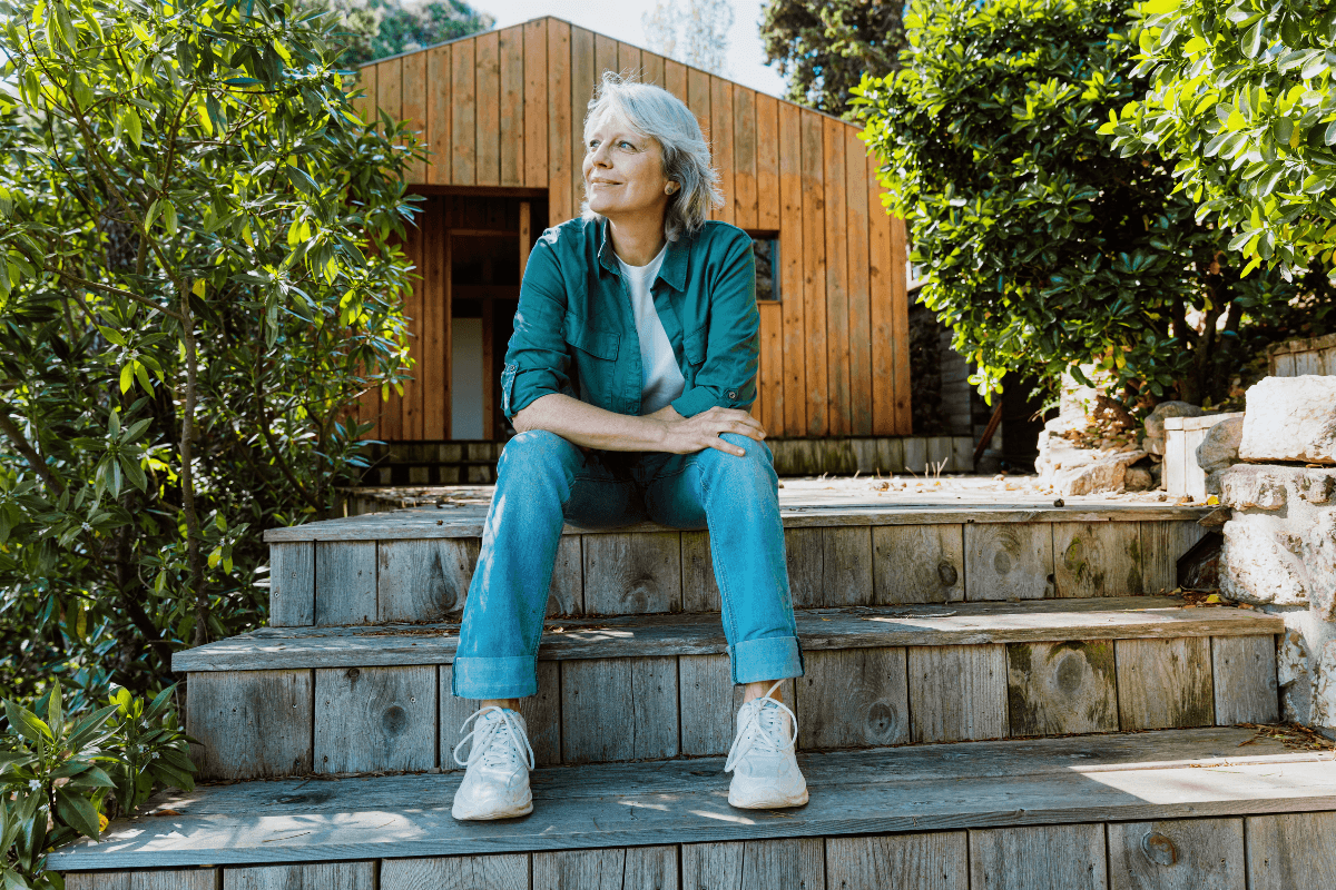 Woman sitting on wooden steps outside cabin