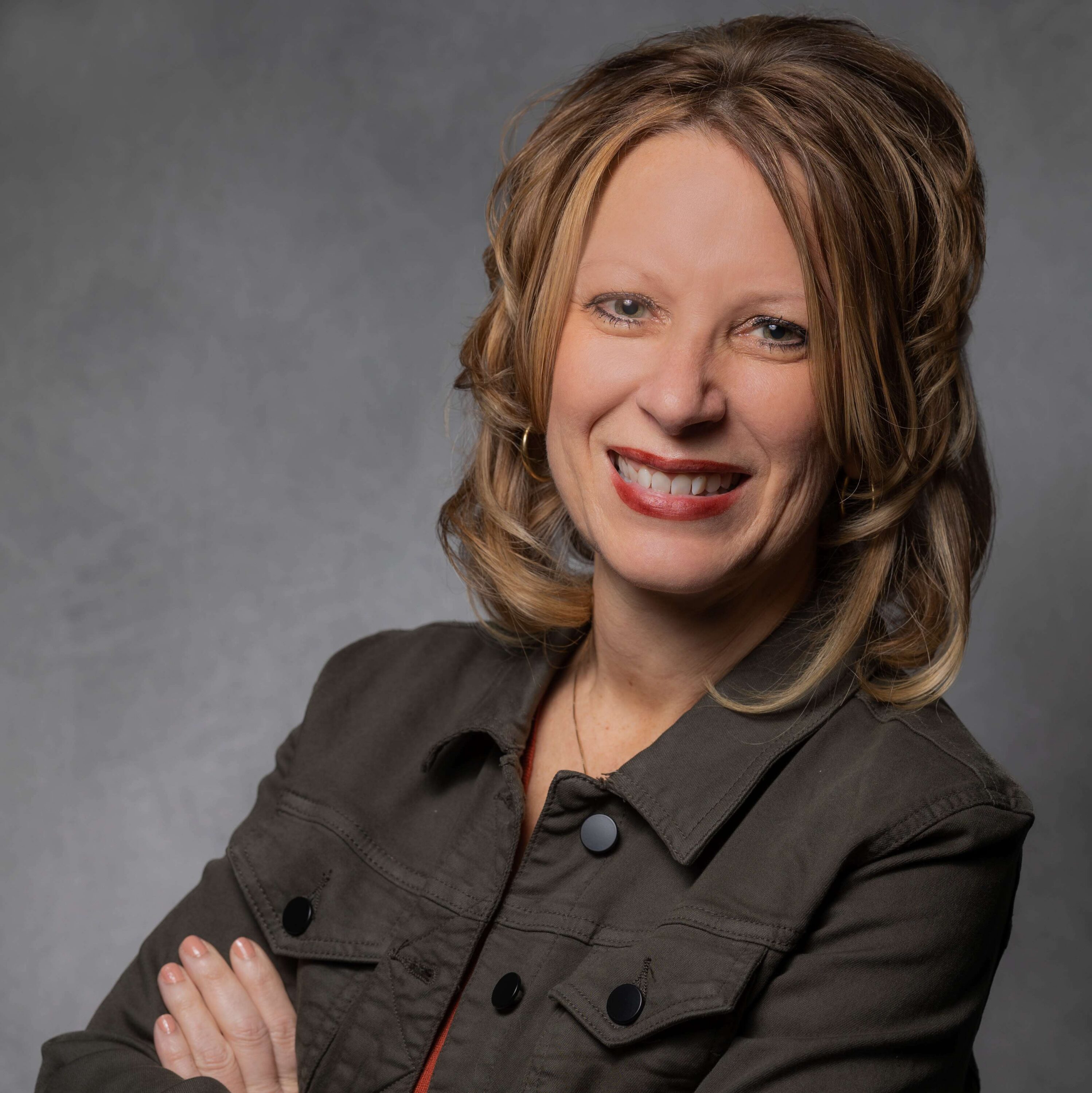 Smiling woman in brown jacket studio portrait