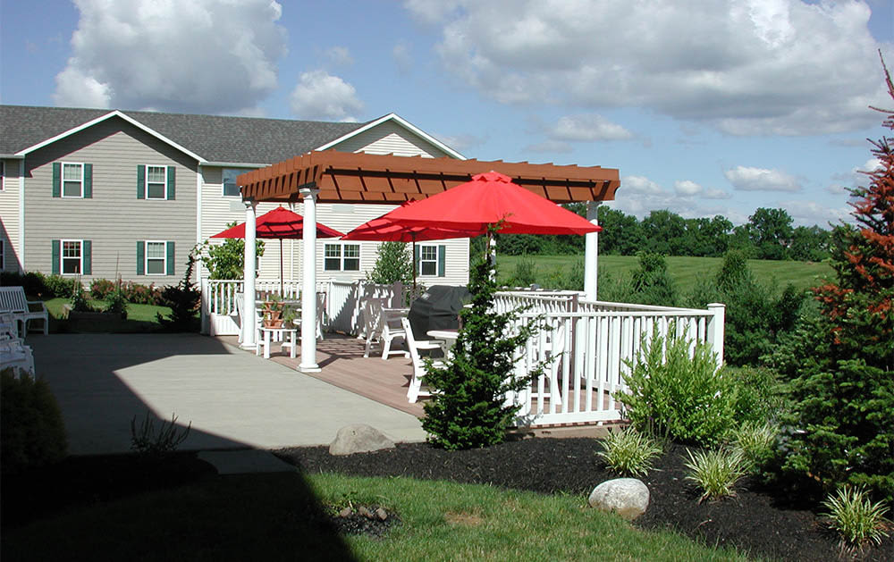Backyard patio with pergola and red umbrellas