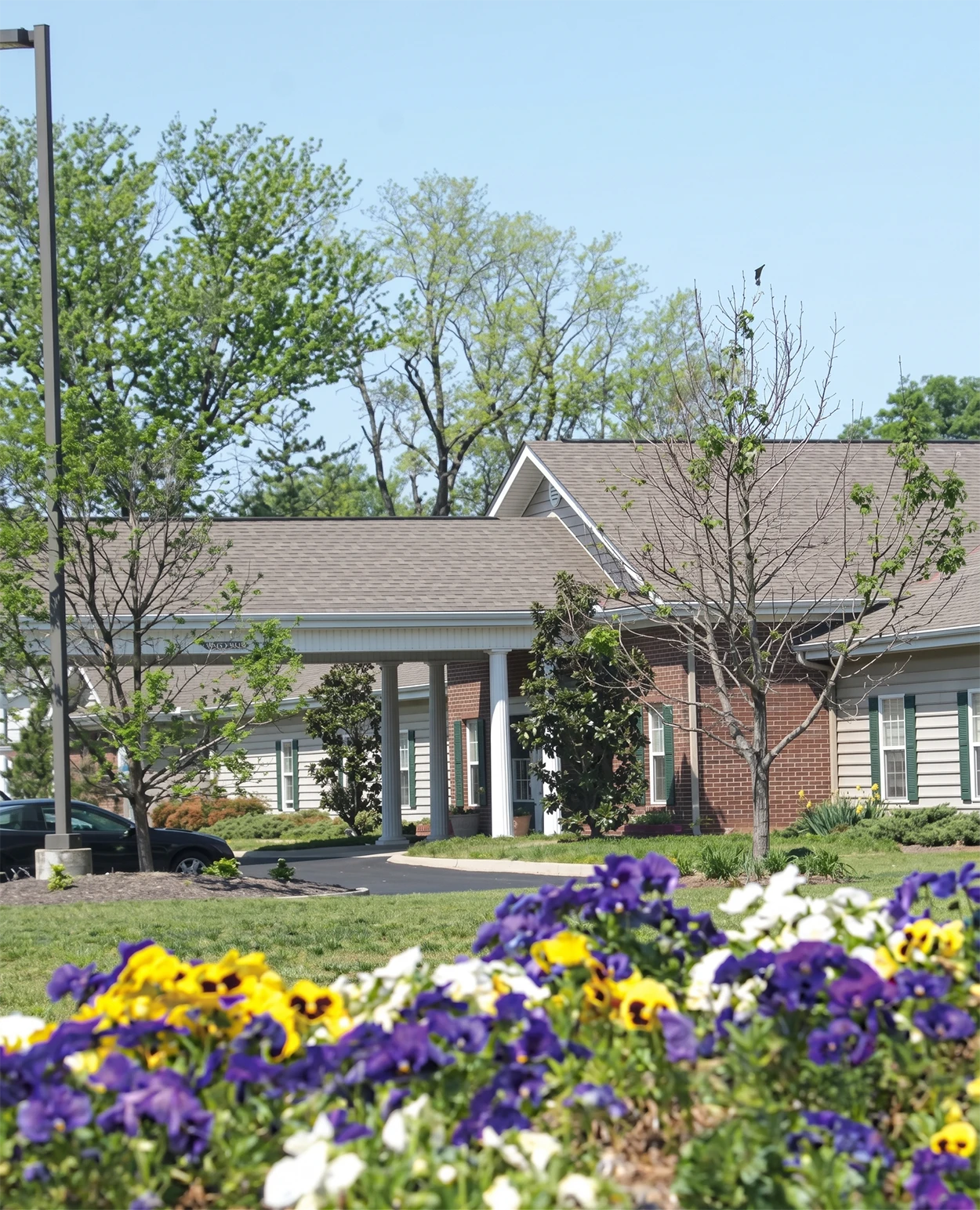 Brick building with columns and colorful flowers