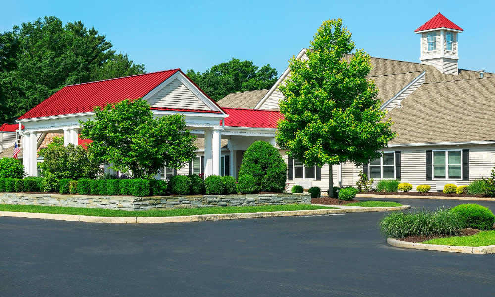 Community clubhouse with red roof and landscaped entrance