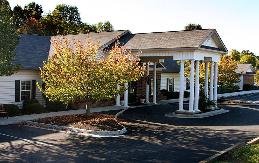 Single-story building with columns and autumn tree
