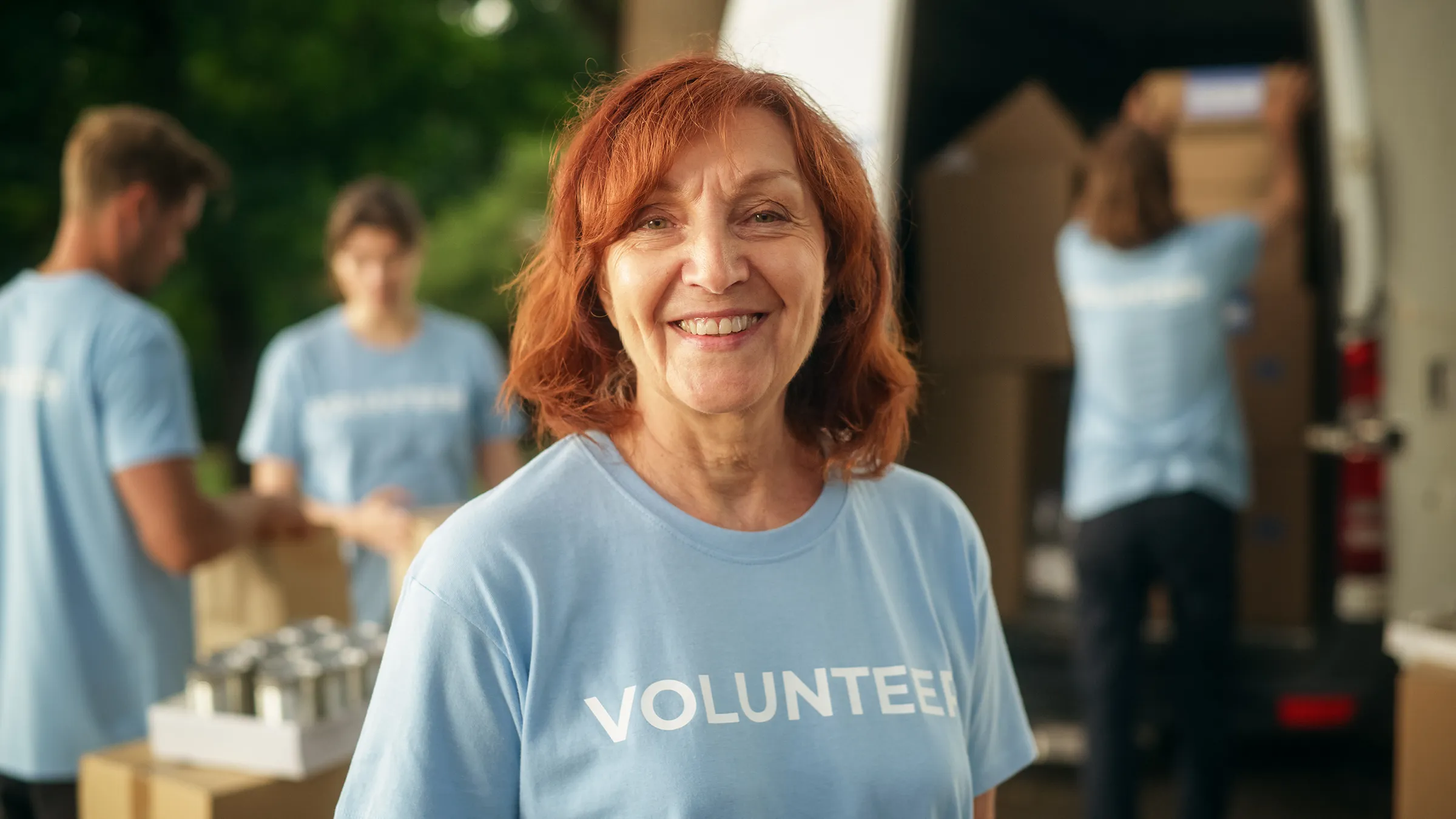 Smiling volunteer in blue shirt at food drive